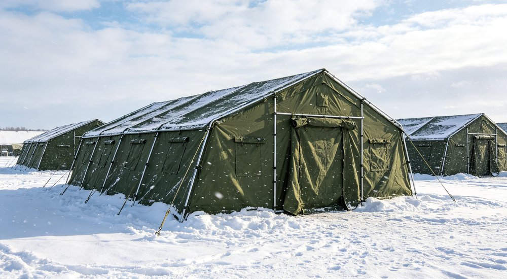 Professional emergency relief tent photographed in field deployment showing sturdy construction waterproof fabric and steel frame design suitable for disaster response and humanitarian aid operations