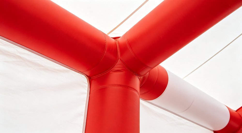 Close-up detail of inflatable tent air beam structure showing reinforced PVC coated polyester fabric and welded seams, professional product detail photography