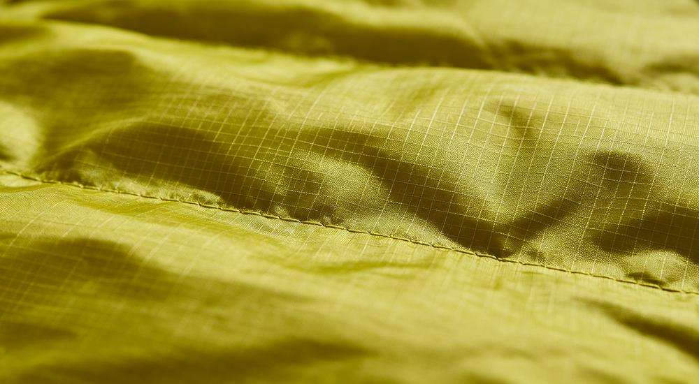 Close up of ripstop sleeping bag fabric texture, anti-tear grid pattern material, durable outer shell detail, macro photography