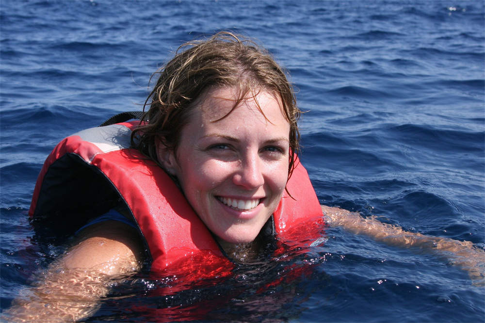 Person swimming in ocean wearing life jacket, PFD use for water safety and personal flotation device demonstration Person swimming in ocean wearing life jacket, PFD use for water safety and personal flotation device demonstration
