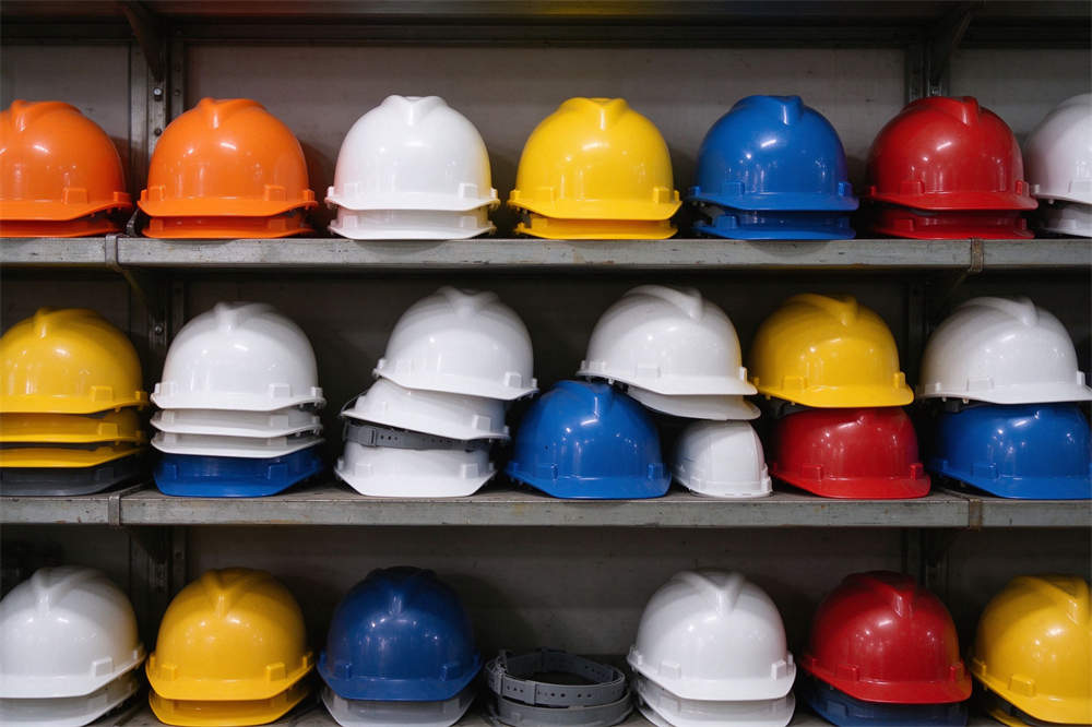 Safety helmets multiple colors on rack: orange white yellow blue red, volcano rescue PPE for emergency operations